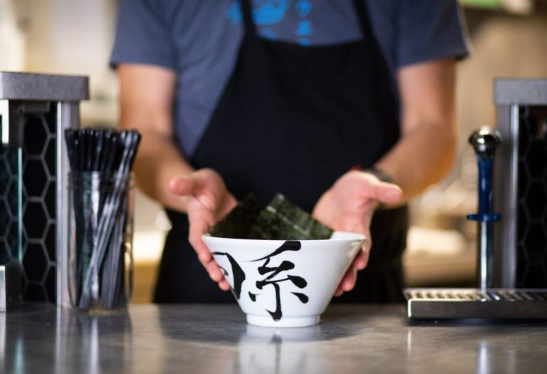 Server presenting a ramen bowl
